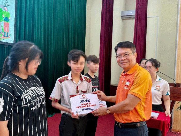 Ông Nguyễn Thành Lợi – Bí thư Đảng ủy, Chủ tịch HĐND xã Bình Chánh trao học bổng động viên các em mồ côi do ảnh hưởng đại dịch COVID-19