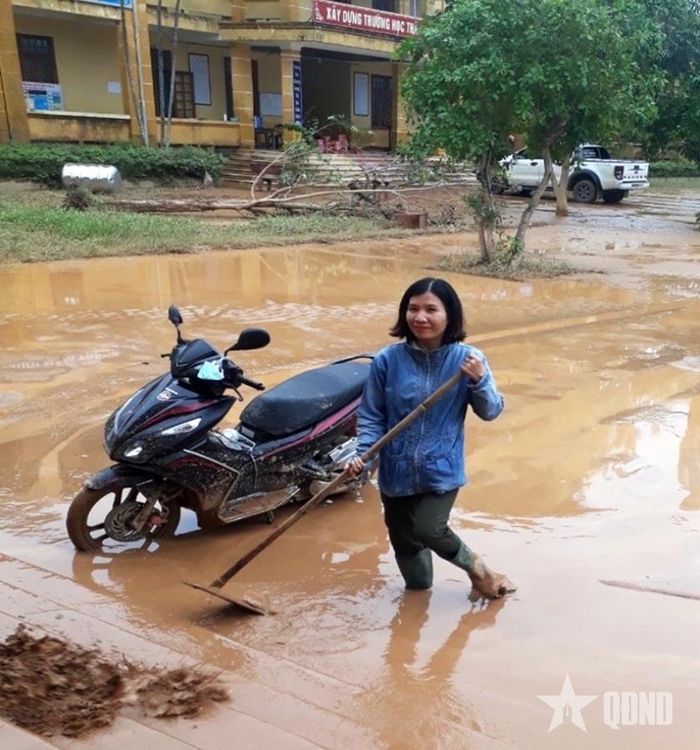  Cô Hồ Thị Tuyết vệ sinh sân trường sau lũ lụt ở điểm trường Trấm. 