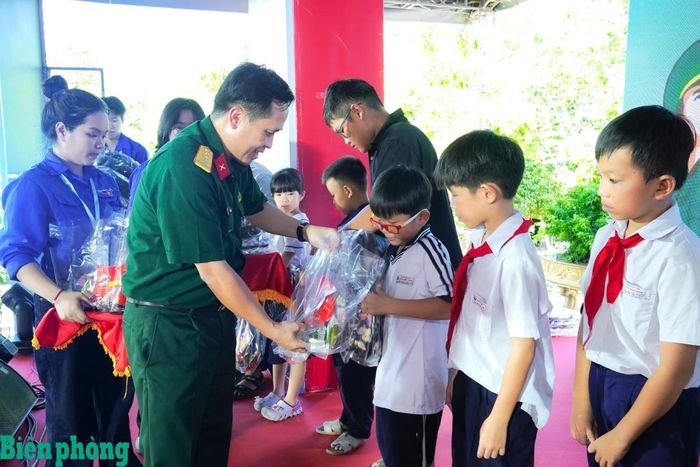 Thượng tá Đỗ Quốc Bảo, Phó Chủ nhiệm Chính trị Bộ Tư lệnh thành phố tặng quà cho các em học sinh trong chương trình “Nâng bước em tới trường”. Ảnh: Văn Danh
