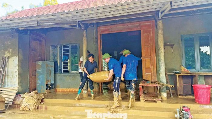 Đoàn viên, thanh niên xã Xuân Lương thu dọn bùn đất giúp người dân sau lũ.