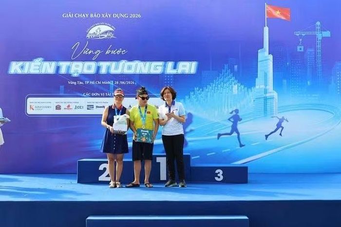 Bà Nguyễn Thị Hồng Nga, Tổng Biên tập báo Xây dựng, Trưởng Ban tổ chức trao món quà động viên 2 mẹ con chị Nguyệt Bùi