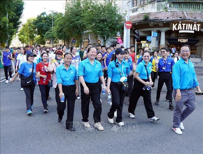 Đoàn viên Công đoàn phường Hòa Hưng tham gia Chương trình đi bộ đồng hành kỷ niệm 50 năm Ngày Thành phố Sài Gòn - Gia Định chính thức vinh dự mang tên Chủ tịch Hồ Chí Minh. Ảnh: Trung Tuyến/TTXVN