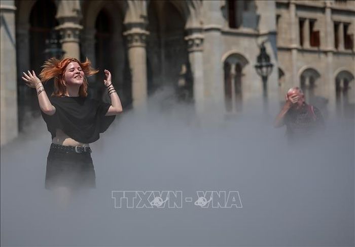 Người dân làm mát bằng hệ thống phun sương ở Budapest, Hungary ngày 24/6/2026. Ảnh: THX/TTXVN