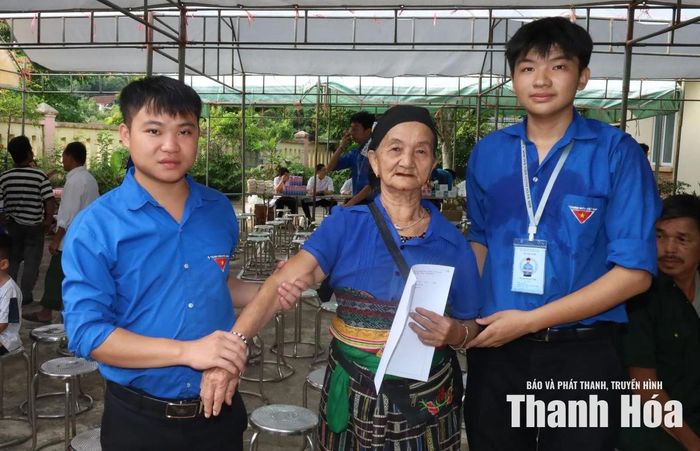 Lực lượng sinh viên tình nguyện giúp đỡ người dân di chuyển vào khu vực khám bệnh.