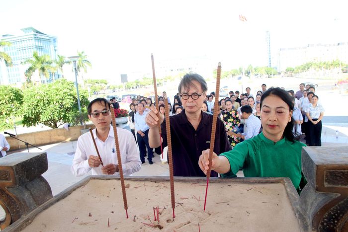 Đạo diễn, NSND Trần Lực (giữa) và các đại biểu dâng hương tại Đài Tưởng niệm thành phố. Ảnh: TRỌNG HUY