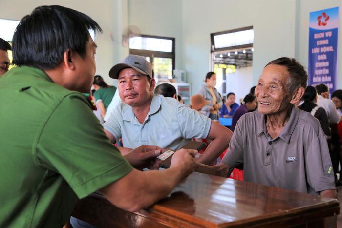 Lực lượng Công an xã Tam Anh hỗ trợ người dân kích hoạt tài khoản định danh điện tử VNeID. Ảnh: ALĂNG NGƯỚC