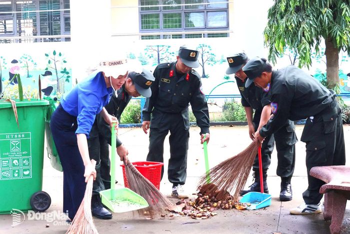 Cán bộ, chiến sĩ Trung đoàn Cảnh sát Cơ động số 9 phối hợp địa phương làm vệ sinh môi trường tại các điểm hành quân dã ngoại. Ảnh: Nguyệt Hà