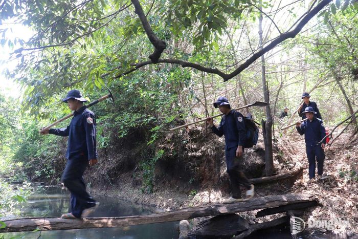 Dù gặp khó khăn, vất vả của thời tiết nhưng các thành viên đội vẫn miệt mài băng rừng, vượt cầu đi tìm kiếm liệt sĩ. Ảnh: ĐVCC