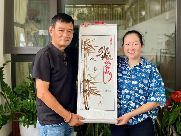  Ông Trần Ngọc Dũng và chị Phan Thị Kim Thanh bên một bức tranh thư pháp vẽ bằng mực cà phê vừa hoàn thiện. Ảnh: Lam Nguyên 