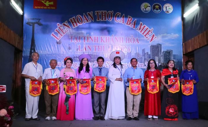 Đại diện Ban tổ chức liên hoan trao cờ lưu niệm cho các đoàn tham gia.