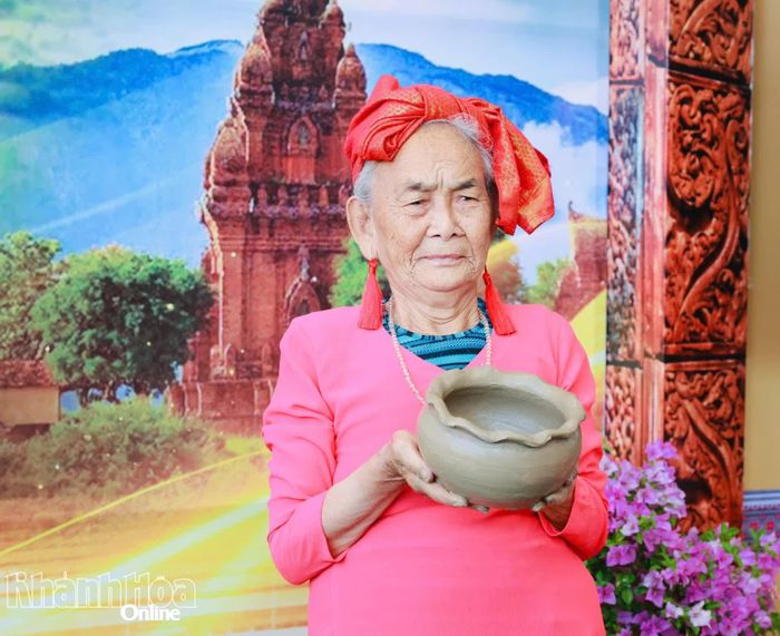 Nghệ nhân Trượng Thị Gạch giới thiệu một sản phẩm gốm Chăm do bà trực tiếp làm tại ngày hội.