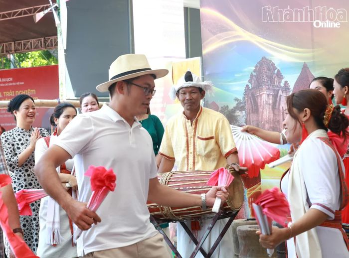 Anh Phạm Văn Vương (du khách đến từ Quảng Ngãi) múa quạt cùng các thiếu nữ Chăm của Khánh Hòa.