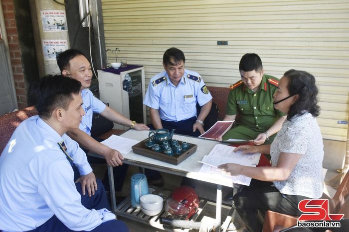 Cán bộ Đội QLTT số 6 tuyên truyền cho hộ kinh doanh trên địa bàn xã Sông Mã chấp hành quy định của pháp luật.