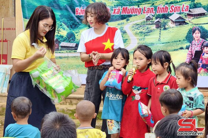 Đại diện CLB Love and Share trao bánh kẹo cho học sinh.