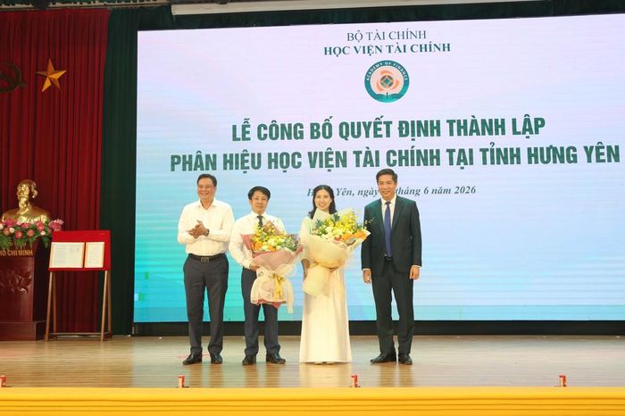 Phó Bí thư chuyên trách Đảng ủy Bộ Tài chính Đỗ Văn Trường (ngoài cùng bên trái) và Giám đốc Học viện Tài chính Nguyễn Đào Tùng tặng hoa Ban Giám đốc phân hiệu.