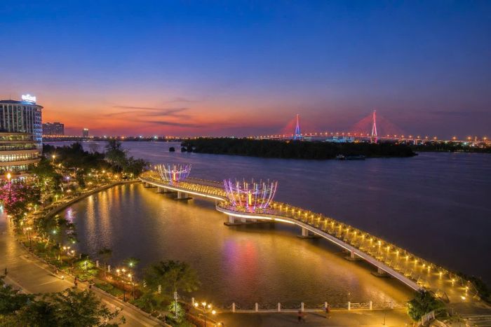 Cầu đi bộ Ninh Kiều nổi bật với biểu tượng hai bông sen phát sáng, trở thành điểm ngắm toàn cảnh Bến Ninh Kiều và dòng Hậu Giang đẹp nhất khi màn đêm buông xuống. Ảnh: Đông Dương.