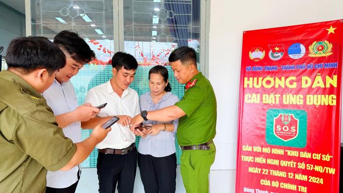 Công an xã Đông Thạnh hướng dẫn người dân cài đặt ứng dụng “SOS an ninh, trật tự”.