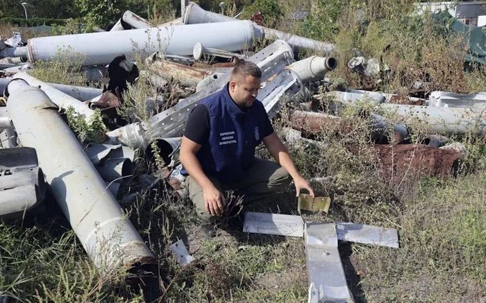 Một chuyên gia Ukraine kiểm tra các loại vũ khí Nga thu thập được ở Kharkov. Ảnh: Reuters