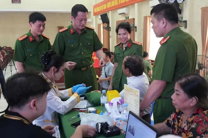 Đại tá Nguyễn Đức Cường, Phó Giám đốc Công an tỉnh thăm hỏi, động viên thân nhân liệt sĩ tại điểm thu nhận mẫu sinh phẩm ADN ở phường Trường Vinh