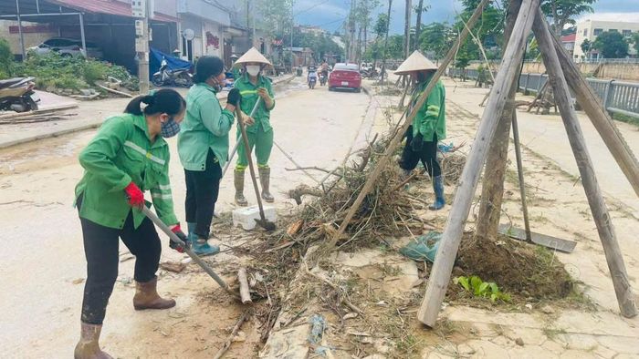 Công nhân môi trường tiến hành dọn rác, bùn sau khi nước sông rút.