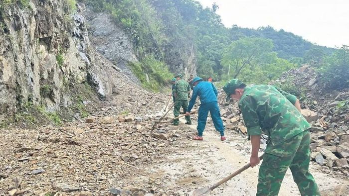 Cán bộ, chiến sĩ Đồn Biên phòng Cô Ba tham gia khắc phcụ đoạn đường bị sạt lở do mưa lớn đêm 25/6.