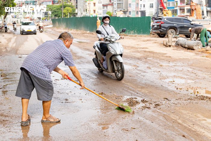 Đất đá vương vãi trước cửa buộc người dân phải thường xuyên ra đường quét dọn để cải thiện phần nào tình trạng vệ sinh.