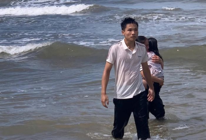 Em Lê Đức Trung cùng cháu bé vào bờ an toàn. (Ảnh: Hàn Nguyên)