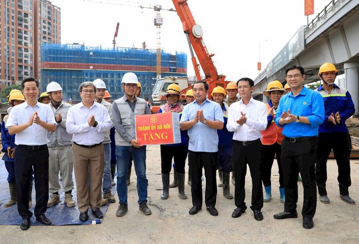 Bí thư Thành ủy Hà Nội Trần Đức Thắng; Phó Bí thư Thường trực Thành ủy Hà Nội Nguyễn Trọng Đông cùng các đồng chí lãnh đạo thành phố Hà Nội tặng quà công nhân thi công tại Dự án đầu tư xây dựng hầm chui tại nút giao Cổ Linh. Ảnh: Quang Thái