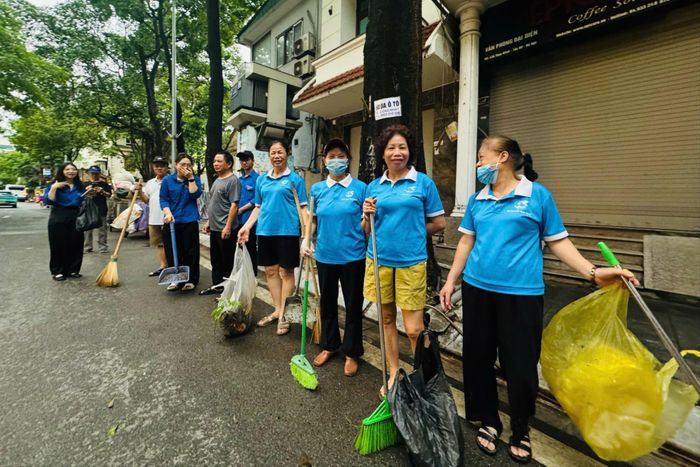 Niềm vui gắn kết tình làng nghĩa xóm thông qua hoạt động vệ sinh đường phố khu dân cư. Ảnh: Mai Hoa
