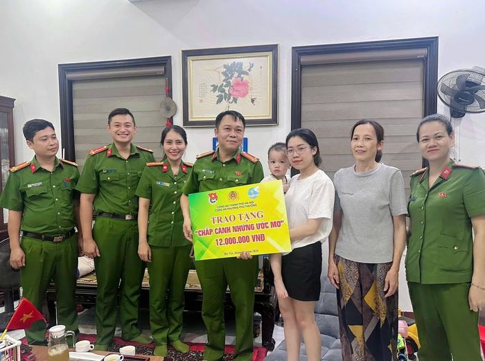 Đoàn công tác của Công an phường Phú Thượng trao phần quà trị giá 12 triệu đồng cho cháu Nguyễn Anh Vũ. Ảnh: PT