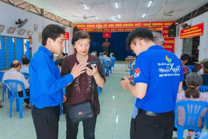  Chiến sĩ Mùa hè số Học viện Cán bộ TP.HCM hướng dẫn các cô chú lớn tuổi làm quen với Sổ tay Đảng viên điện tử. Ảnh: NVCC 