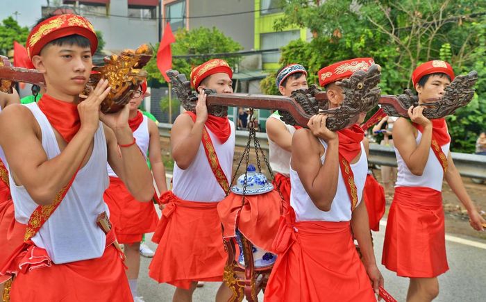 Những người đội phù giá nâng chóe nước thiêng trên vai, cẩn trọng đưa về đình để phục vụ các nghi lễ tế.