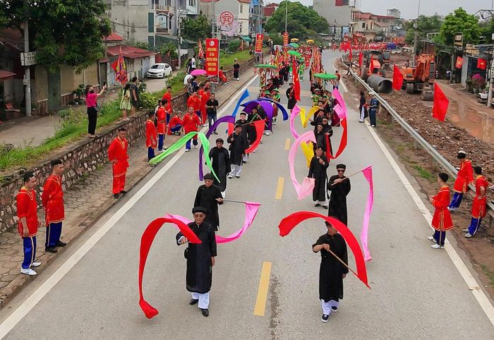 Đoàn rước kéo dài trên bờ đê với sự tham gia của đông đảo cộng đồng dân cư, tạo nên không khí của lễ hội đặc sắc và độc đáo lâu đời. 