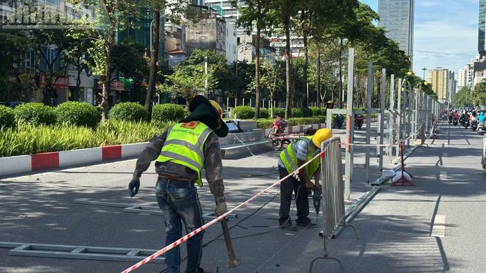 Phía sau hàng rào tạm, nhiều tốp công nhân tất bật thi công, đẩy nhanh tiến độ lắp đặt hệ thống rào chắn cố định trước khi triển khai các hạng mục chính.