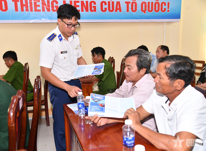  Cán bộ Bộ tư lệnh Vùng Cảnh sát biển 4 phát tờ rơi tuyên truyền cho ngư dân đặc khu Thổ Châu, tỉnh An Giang. 