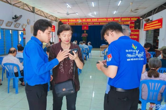  Chiến sĩ Mùa hè số Học viện Cán bộ TP.HCM hướng dẫn các cô chú lớn tuổi làm quen với Sổ tay Đảng viên điện tử. Ảnh: NVCC 