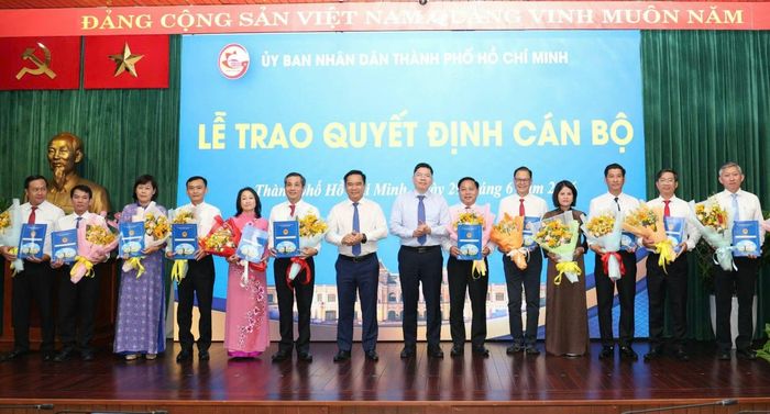  Chủ tịch UBND TPHCM Nguyễn Văn Được, Phó Chủ tịch UBND TPHCM Hoàng Nguyên Dinh trao quyết định và tặng hoa đến các cán bộ. Ảnh: NGÔ BÌNH 