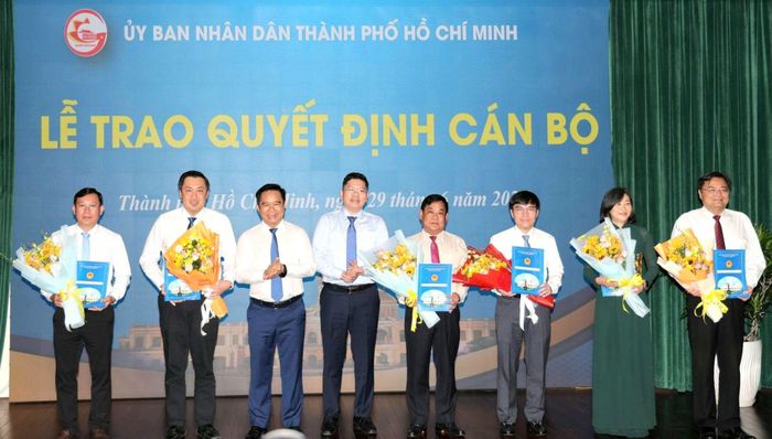 Chủ tịch UBND TPHCM Nguyễn Văn Được, Phó Chủ tịch UBND TPHCM Hoàng Nguyên Dinh trao quyết định và tặng hoa đến cán bộ. Ảnh: NGÔ BÌNH 