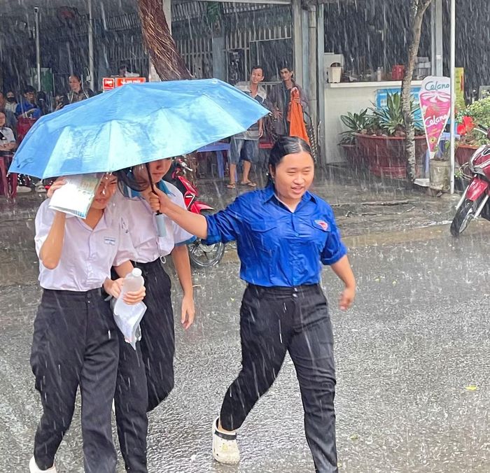  Thanh niên tình nguyện dầm mưa hỗ trợ thí sinh thi tuyển sinh vào lớp 10 tại điểm thi trường THPT Bình Thủy, TP. Cần Thơ. 