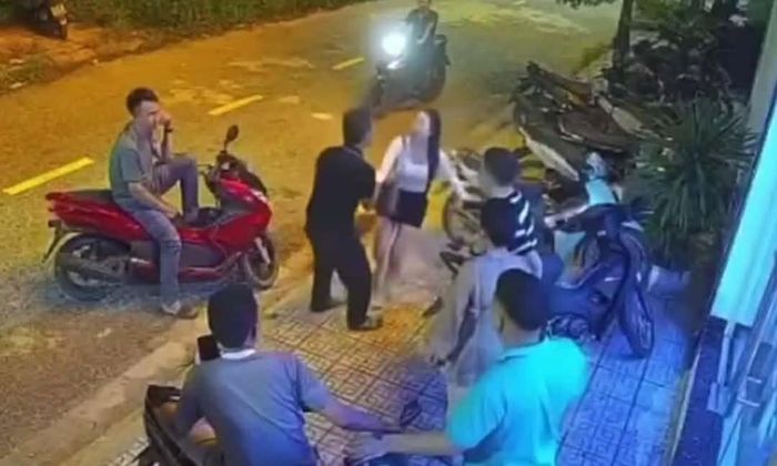 Cô gái vừa đến cửa quán karaoke thì bị một người đàn ông kéo lại phía mình. Ảnh: Cắt từ clip