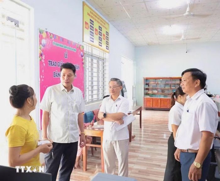 Bí thư Đảng ủy xã Bù Gia Mập Lê Hoàng Nam thăm hỏi người dân khi thực hiện thủ tục hành chính tại Trung tâm Phục vụ hành chính công xã. (Ảnh: K GƯỈH/TTXVN)