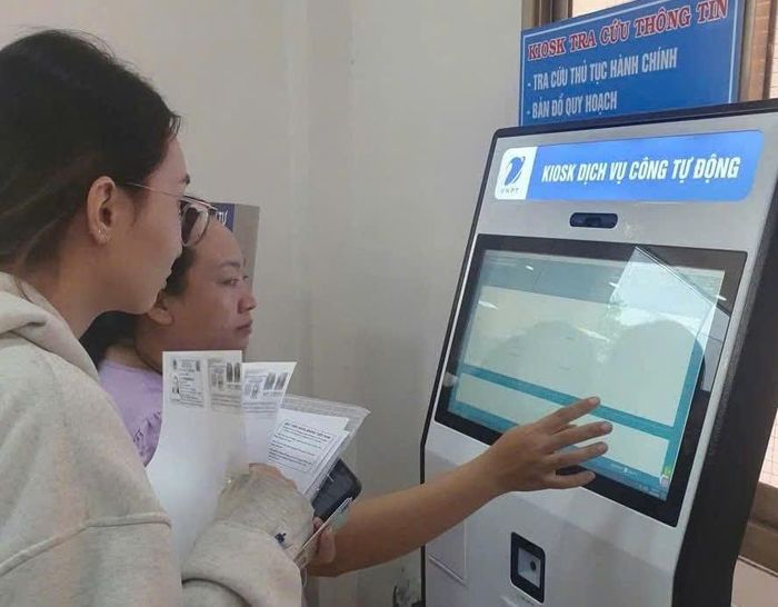 Các bộ hành chính công hướng dẫn người dân nộp hồ sơ điện tử tại các kiot điện tử ở Trung tâm Phục vụ hành chính công phường Tân Bình.