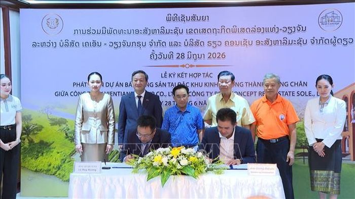 Ông Lê Huy Hoàng, Tổng Giám đốc Công ty TNHH KN Viêng Chăn Group và ông Bouavieng Champaphan, Giám đốc Công ty TNHH Bất động sản Real Concept ký kết văn kiện hợp tác trước sự chứng kiến của các đại biểu. Ảnh: Văn Phiên/PV TTXVN tại Lào