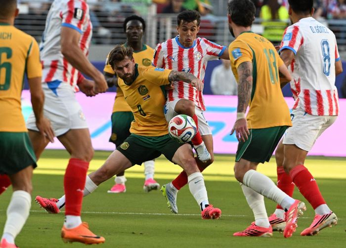 Pha tranh bóng giữa tiền vệ Australia Connor Metcalfe (giữa, áo vàng) và tiền vệ Paraguay Andres Cubas. Ảnh: THX/TTXVN