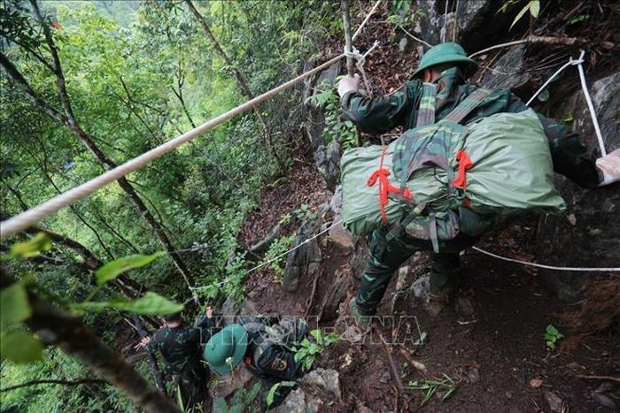 Hành trình đưa hài cốt liệt sĩ từ điểm cao 685 (thôn Nặm Ngặt, xã Thanh Thủy) về nhà chờ. Ảnh: Hoàng Hiếu/TTXVN