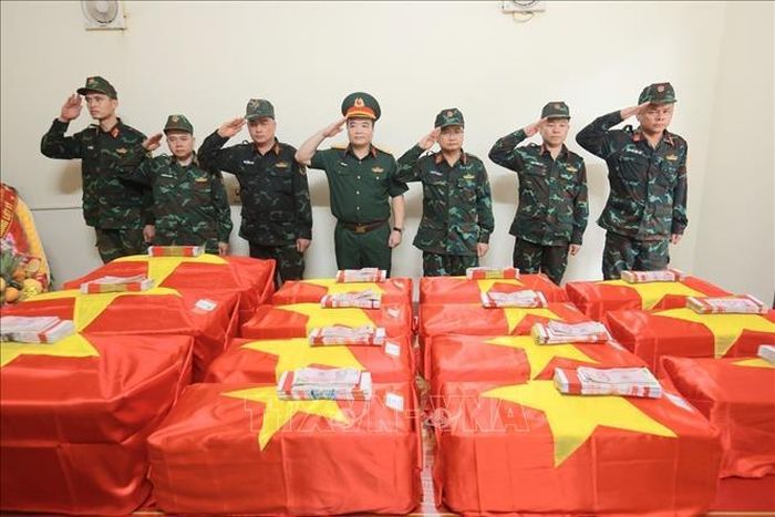 Đại tá Nguyễn Minh Khôi, Phó Chính ủy Bộ Chỉ huy Quân sự tỉnh Tuyên Quang (giữa) và các cán bộ, chiến sĩ tri ân các liệt sĩ đã hy sinh tại mặt trận Vị Xuyên. Ảnh: Hoàng Hiếu/TTXVN