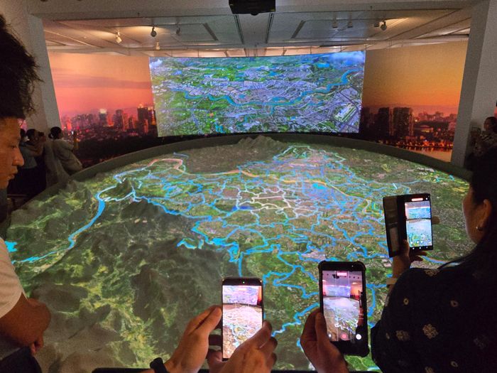 Nhiều người dân chăm chú theo dõi và ghi lại phần trình chiếu Mapping 3D tái hiện không gian phát triển của Hà Nội trong tầm nhìn 100 năm. Ảnh: Văn Xuyên/BNEWS/TTXVN