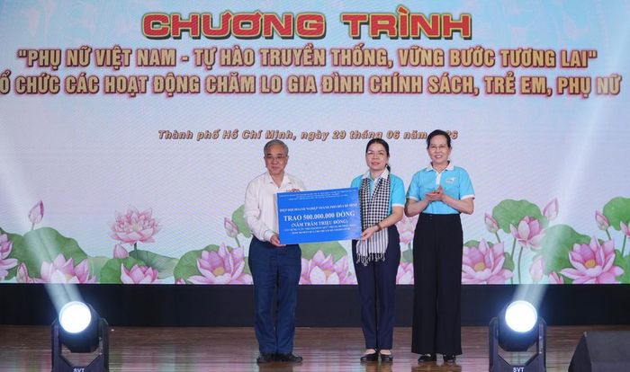 Với sự chứng kiến của bà Lê Thị Thủy (bìa phải), Ủy viên TƯ Đảng, Phó Chủ tịch UBTƯ MTTQ Việt Nam, Chủ tịch Hội LHPN Việt Nam, ông Nguyễn Ngọc Hòa, Chủ tịch Hiệp Hội Doanh nghiệp TPHCM, trao bảng tượng trưng số tiền trị giá 500 triệu đồng để xây dựng "Nhà Đại đoàn kết" và trao quà cho trẻ em mồ côi do Covid-19 cho bà Nguyễn Thị Ngọc Xuân, Chủ tịch Hội LHPN TPHCM