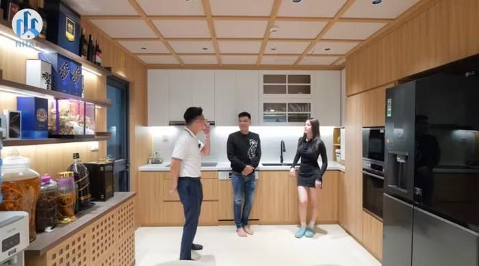 Nếu phòng khách là "lãnh địa" của Trung Ruồi thì căn bếp gần như thuộc quyền thiết kế của vợ anh. Toàn bộ hệ tủ được thiết kế kịch trần nhằm tối ưu không gian lưu trữ. Mọi thiết bị như tủ lạnh, lò nướng, lò vi sóng hay khu vực chứa đồ khô đều được bố trí khoa học và kín đáo