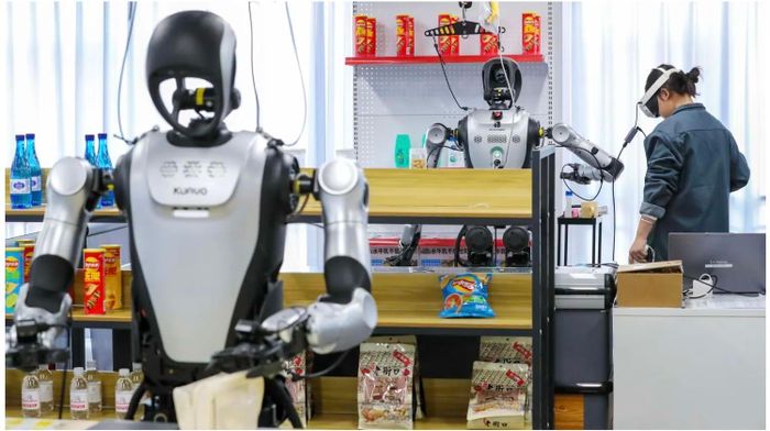 Con người đang huấn luyện một robot các thao tác sắp xếp các đồ vật tại một trung tâm dữ liệu. Dự kiến robot sẽ thay thế hàng trăm ngàn lao động từ sản xuất đến phục vụ cao cấp. Ảnh: Getty Image